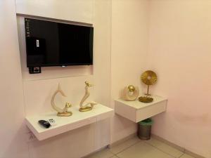 a room with a tv and some statues on shelves at Skylines Zirakpur in Zirakpur