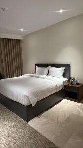 a bedroom with a large bed with white sheets and pillows at نون Noon in Medina