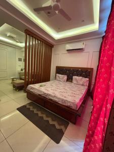 a bedroom with a large bed with a red curtain at Skylines Zirakpur in Zirakpur