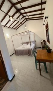 a room with a bed and a table in it at Sunny's Hide Out in Talalla South