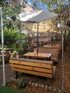 a table and chairs under an umbrella in a garden at Pakakuna in Urubamba