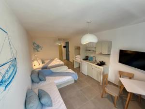 a room with two beds and a kitchen and a table at Apollonia Studios in Katapola