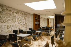 a dining room with tables and chairs and a wall at Hotel Ponta Delgada in Ponta Delgada