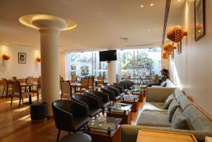 a restaurant with couches and tables and chairs at Hotel Ponta Delgada in Ponta Delgada