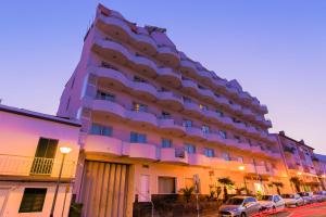 a large building with cars parked in front of it at Hotel Ponta Delgada in Ponta Delgada