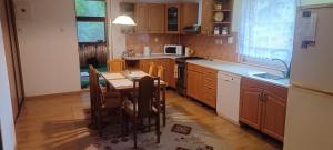 a kitchen with a table with chairs and a microwave at Dovolenkový dom in Klokočov