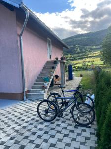 two bikes parked outside of a pink house at Apartman Demirovic in Orašac