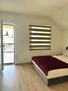 a bedroom with a bed and a large window at Hajr Villa in Ilidža