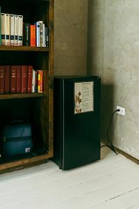 a black refrigerator sitting next to a book shelf at Casa Botanica in San Juan