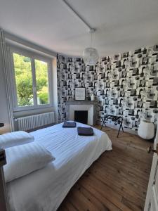 a bedroom with a white bed and a fireplace at L'Ostal De Papi in Saint-Affrique +4 photos
