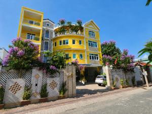a yellow building with flowers in front of it at Ngoc Son Hotel in Bien Hoa