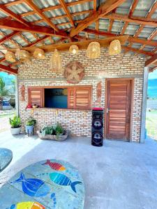 a house with a brick wall and a patio at Loft Azul - Pousada Vila Dondom in Luis Correia