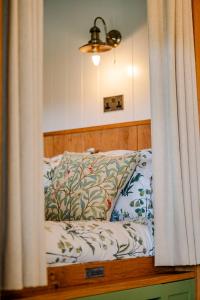 a bedroom with a bed with a wooden headboard at Northcombe Farm Shepherd's Hut in Germansweek