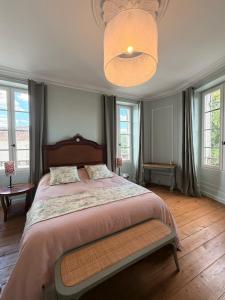 a bedroom with a large bed and a ceiling at La Maison Colette - B&B in Issigeac
