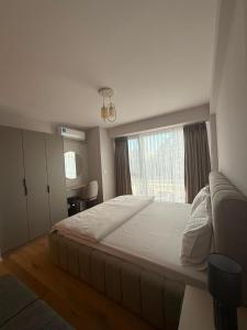 a bedroom with a large bed and a window at Struga Lake Suites in Struga