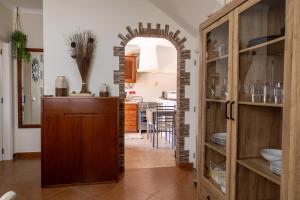 a kitchen with an archway and a dining room at Casa Espadinha in Salema