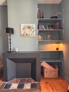 a living room with a fireplace and a table at La Maison Colette - B&B in Issigeac