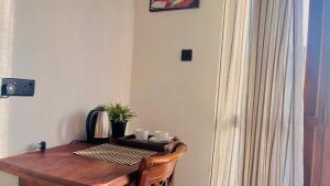 a wooden table with two cups and a plant on it at Ella Scenic Heights in Ella