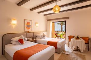 a hotel room with two beds and a table and chairs at Shams Alam Beach Resort in Marsa Alam City +241 photos