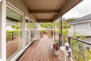 a deck with chairs and tables on a house at Villa with jacuzzi in Nord Bjørøy