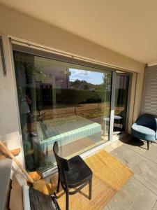 a room with a sliding glass door with a chair and a pool at Apart Leman in Ecublens