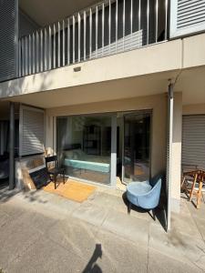 a patio with a blue chair in front of a building at Apart Leman in Ecublens
