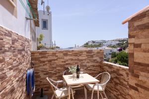 a patio with a table and chairs on a brick wall at Casa Espadinha in Salema