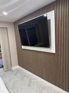 a room with a television on a wall at One Bedroom Spacious House in Cardiff