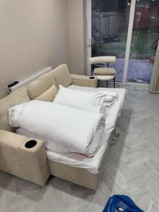 a couch with white pillows on it in a room at One Bedroom Spacious House in Cardiff