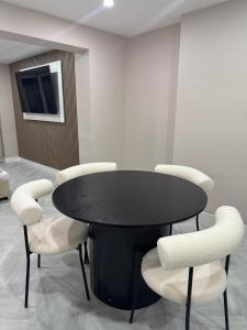 a black table with white chairs in a room at One Bedroom Spacious House in Cardiff