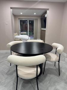 a black table with white chairs in a room at One Bedroom Spacious House in Cardiff
