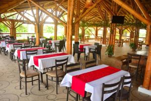a restaurant with tables and chairs with red and white table cloth at Finca Hotel Loma del Café in Pueblorrico