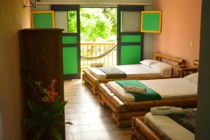 a room with four beds and a balcony at Finca Hotel Loma del Café in Pueblorrico