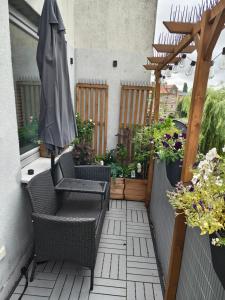a patio with an umbrella and chairs and flowers at Apartament Kamil Kalisz in Kalisz