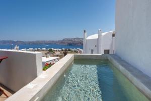 a swimming pool on the side of a building at Arvanitis Cave Village in Akrotiri