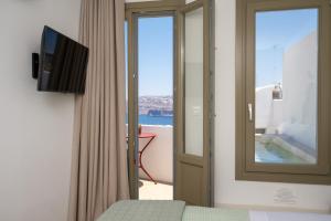 a room with a window and a door with a view at Arvanitis Cave Village in Akrotiri