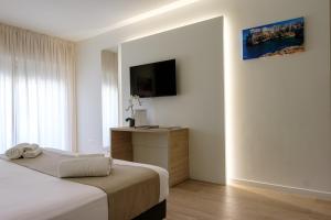 a hotel room with a bed and a television at Hotel Olivò in Bitritto