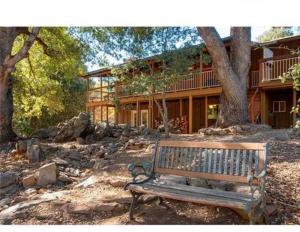 a wooden bench sitting in front of a house at Wolf Den retreat on 20 acres in Julian
