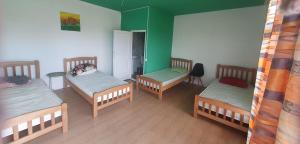 three beds in a room with green walls at Green Village in Grigolaantkari