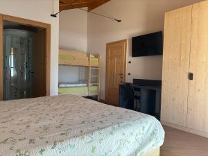 a bedroom with a bed and a flat screen tv at Agriturismo Le Cavade in Cembra