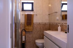 a bathroom with a toilet and a sink at Casa Espadinha in Salema +21 photos