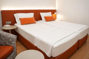 a bedroom with a large bed with two orange pillows at NFK The House Hotel in Antalya +22 photos