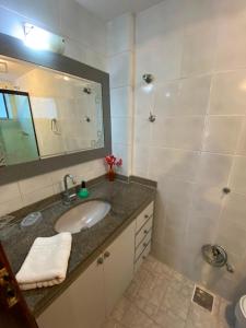 a bathroom with a sink and a mirror at Apto MAR AZUL CARIBE - PRAIA DO FORTE - 3 minutos a pé da praia in Cabo Frio +28 photos