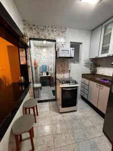 a kitchen with a sink and a stove top oven at Apto MAR AZUL CARIBE - PRAIA DO FORTE - 3 minutos a pé da praia in Cabo Frio