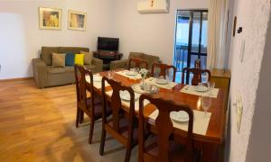 a dining room with a table and a couch at Apto MAR AZUL CARIBE - PRAIA DO FORTE - 3 minutos a pé da praia in Cabo Frio