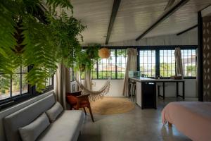 a bedroom with a bed and a desk and windows at Casa Botanica in San Juan