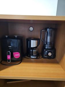 two coffee makers on a shelf in a cabinet at Flat Space Valley - Para 2 Pessoas in São José dos Campos