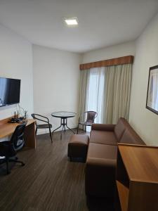 a living room with a couch and a table at Flat Space Valley - Para 2 Pessoas in São José dos Campos