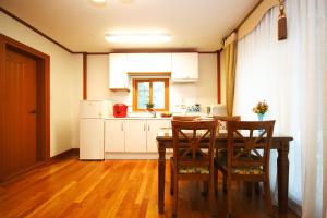 a kitchen with a table and chairs in a room at Starvill Pension in Pyeongchang 
