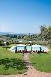 a resort with a pool with umbrellas and grass at Il Martellino in Follonica